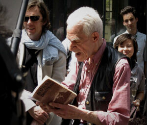 Eddie Woods reading from Harold Norse's BEAT HOTEL in front of the Beat Hotel on Rue Gît-le-Cœur, Paris 2009